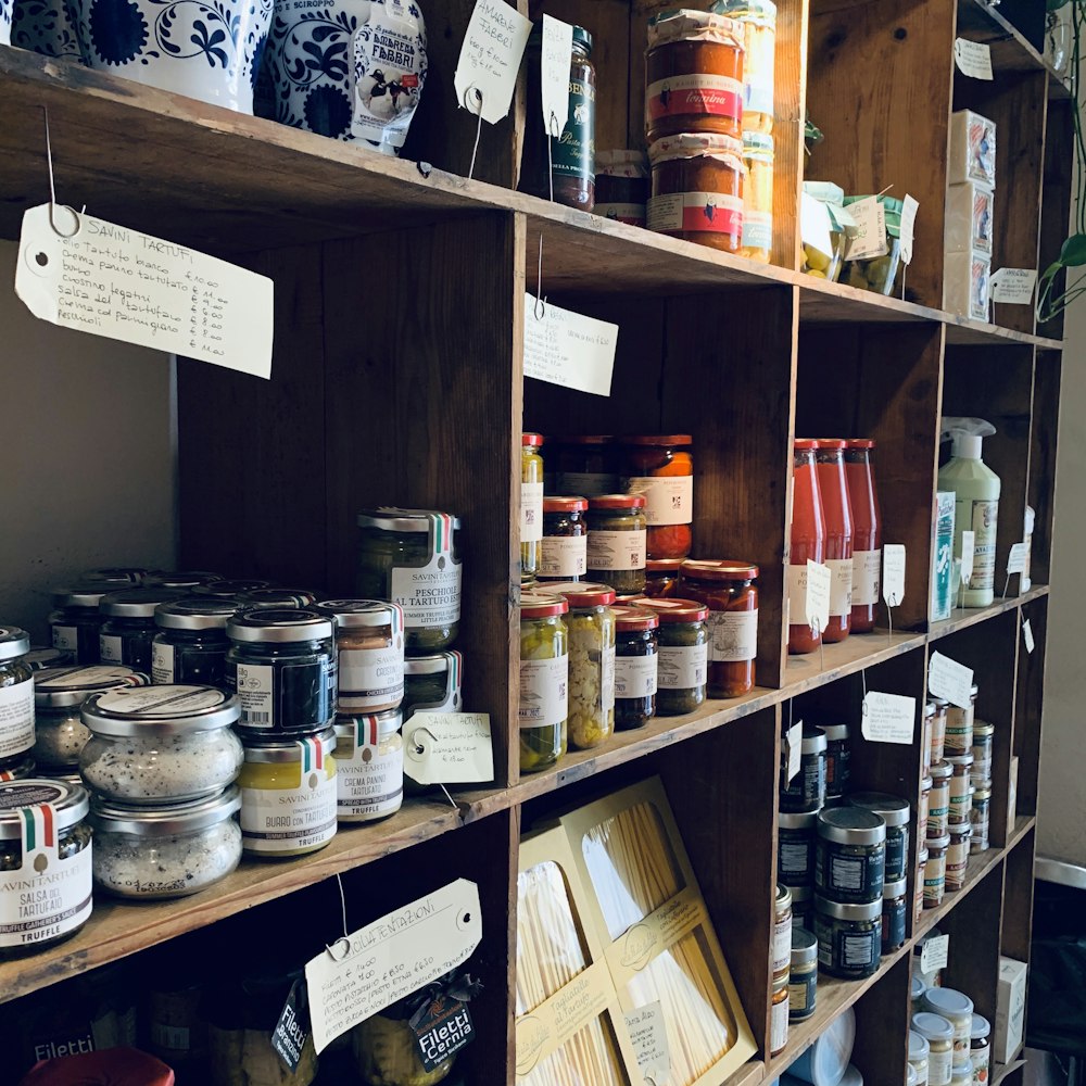 Scaffali di bottega con barattoli di conserve e prodotti artigianali